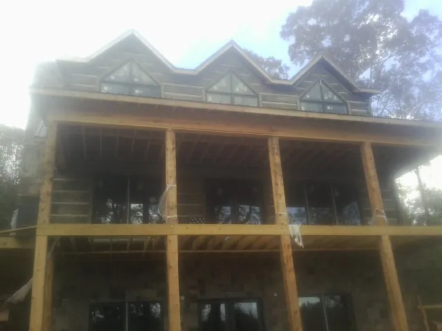 Dormers and porch framing on a large log home under construction — Roof Coating work by our crew in Rocky Face