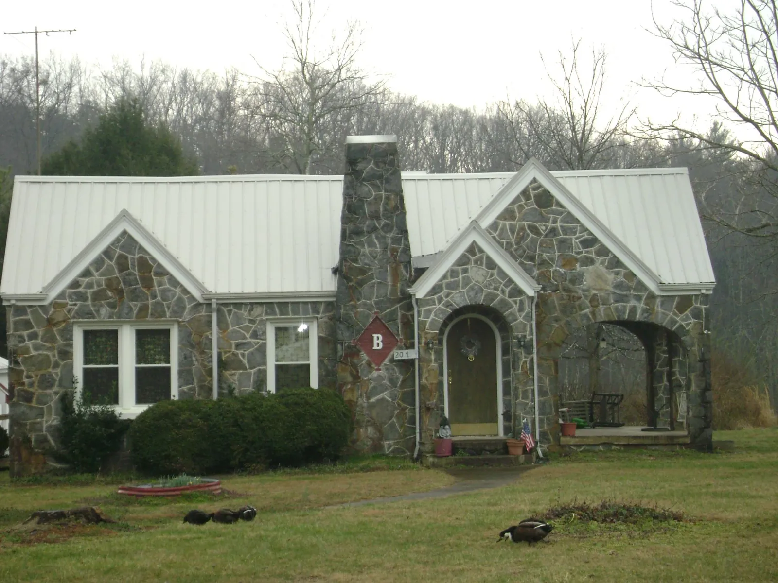 White metal roof on a stone cottage with steep gables in Rocky Face