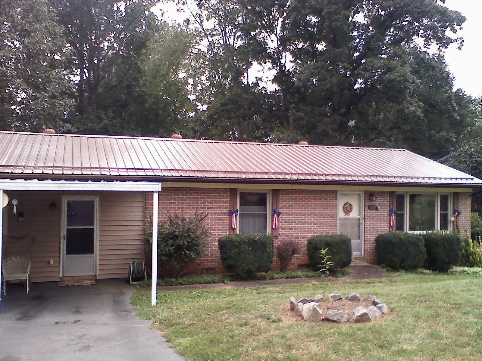 Bronze metal roof and carport on a brick ranch home — Roof Repair work by our crew in Rocky Face